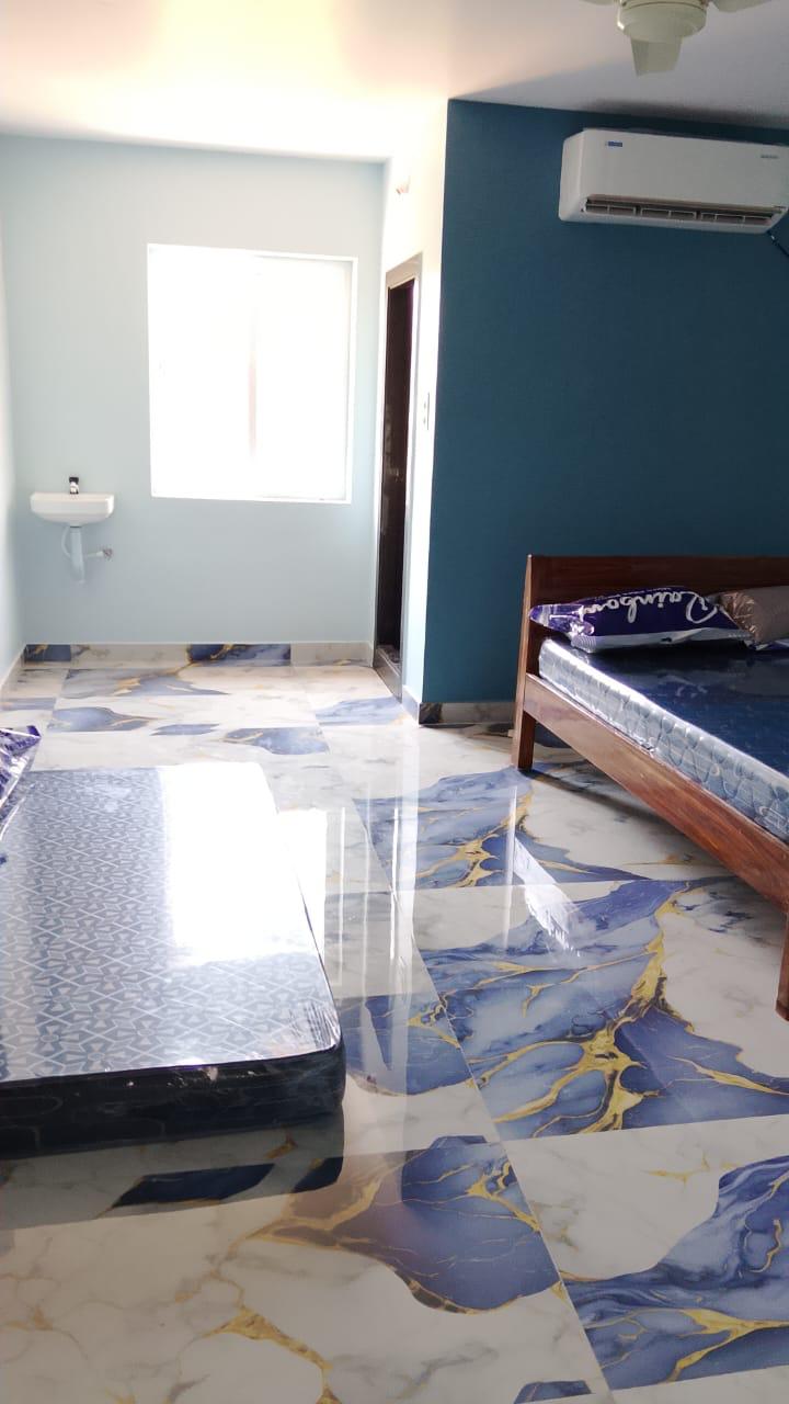 Blue accent room with AC and bed for guest stay