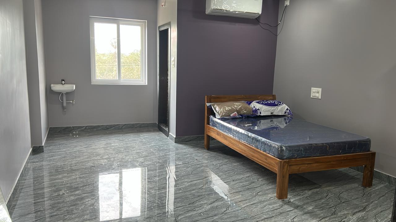 Luxury AC room with wooden bed and glossy floor at Surabhi SJN Convention Hall near Rajahmundry
