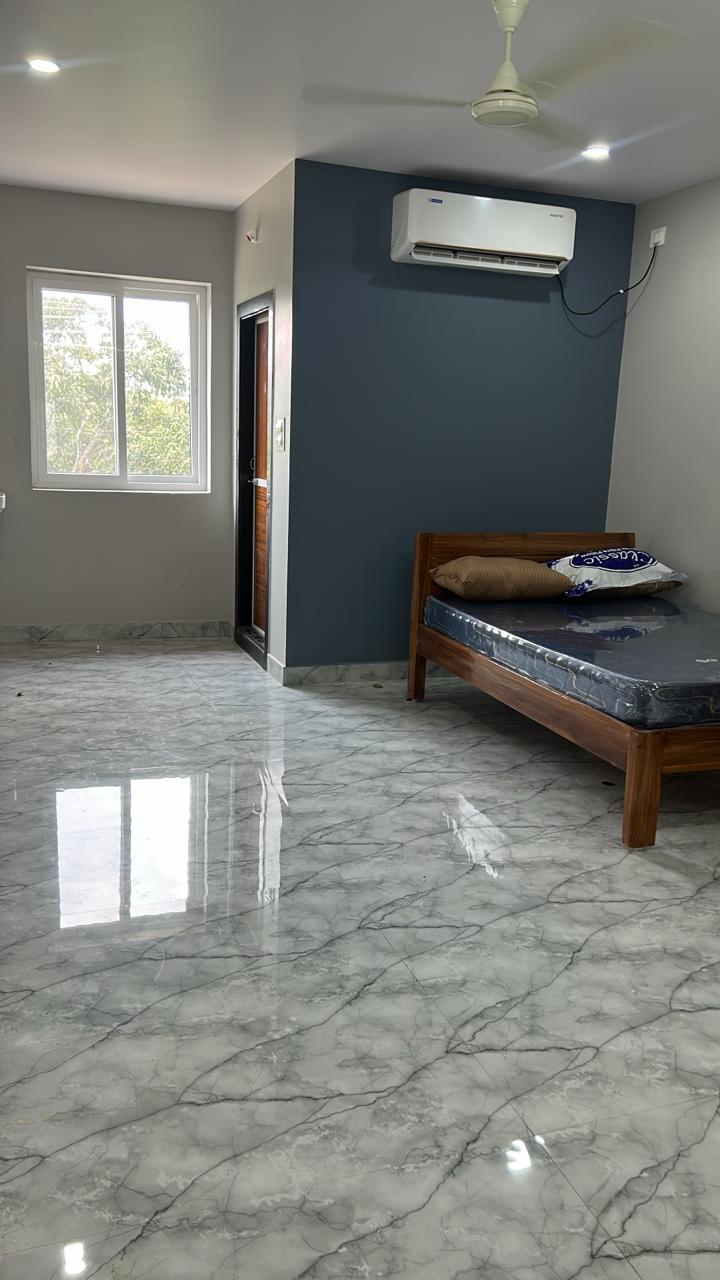 Green wall AC room with wooden bed and polished flooring