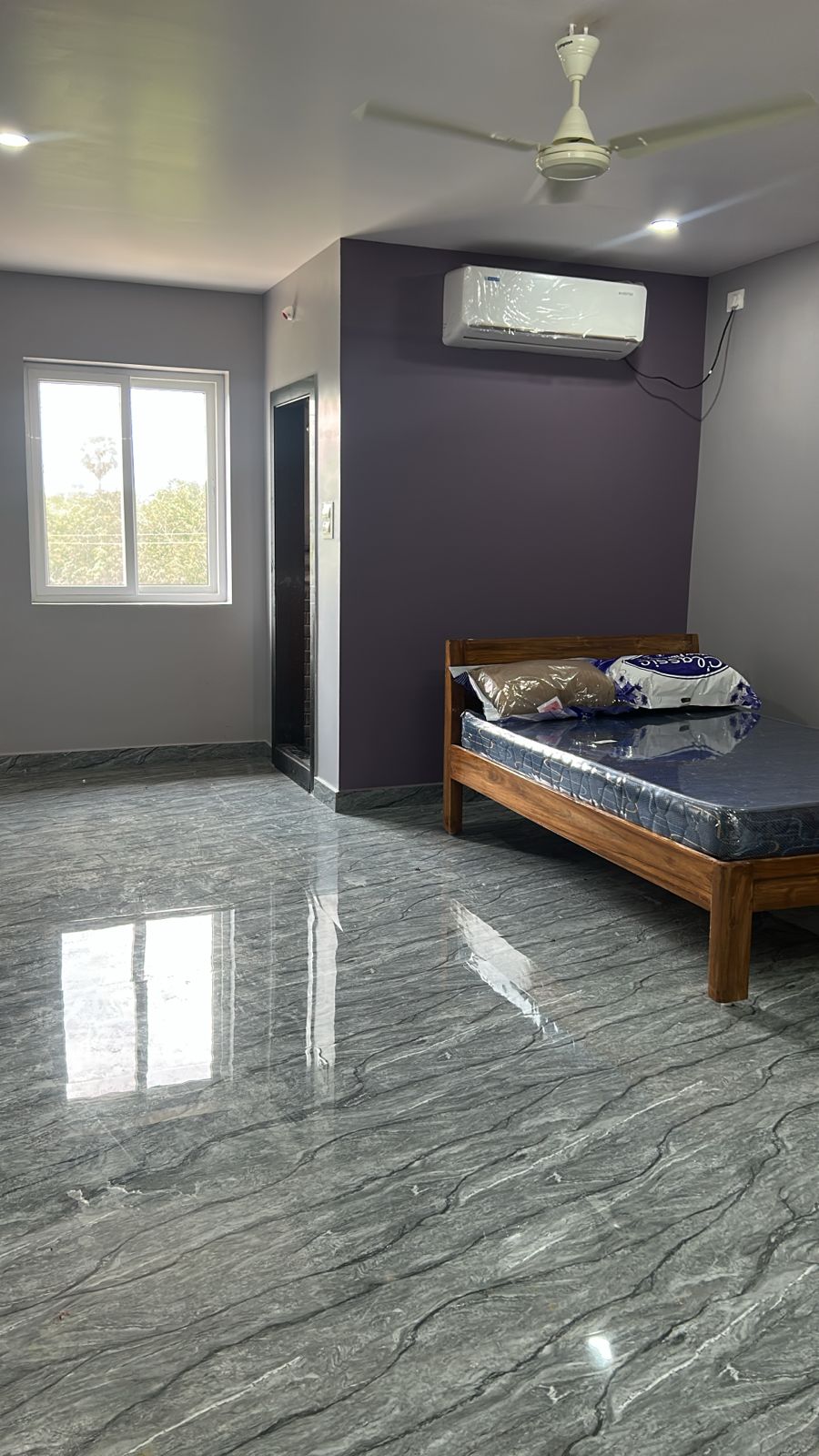 Olive accent AC room with bright window and wooden bed