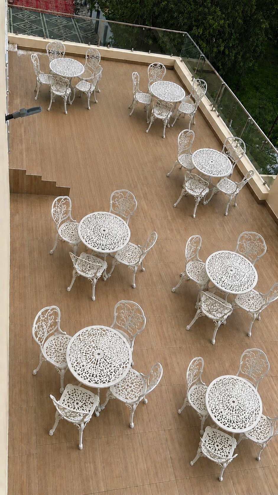 Indoor patio lounge with sofa seating and outdoor tree-view tables at Surabhi SJN